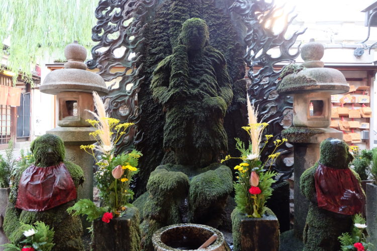 A photo of the Ofudo-san statue covered by the moss